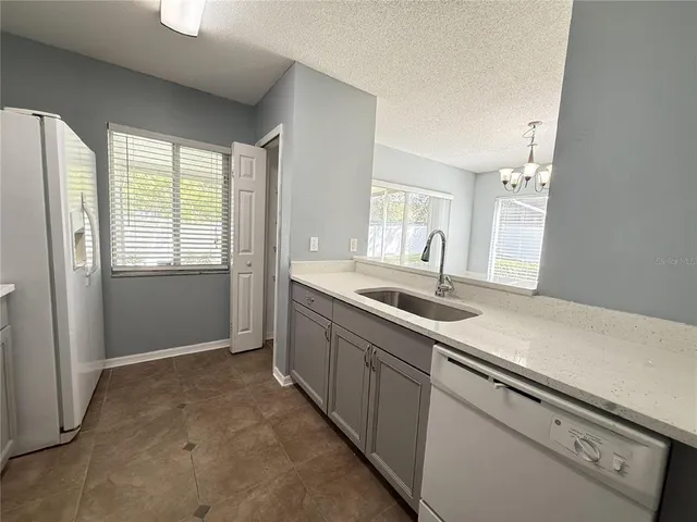a kitchen with granite countertop a sink and a stove top oven