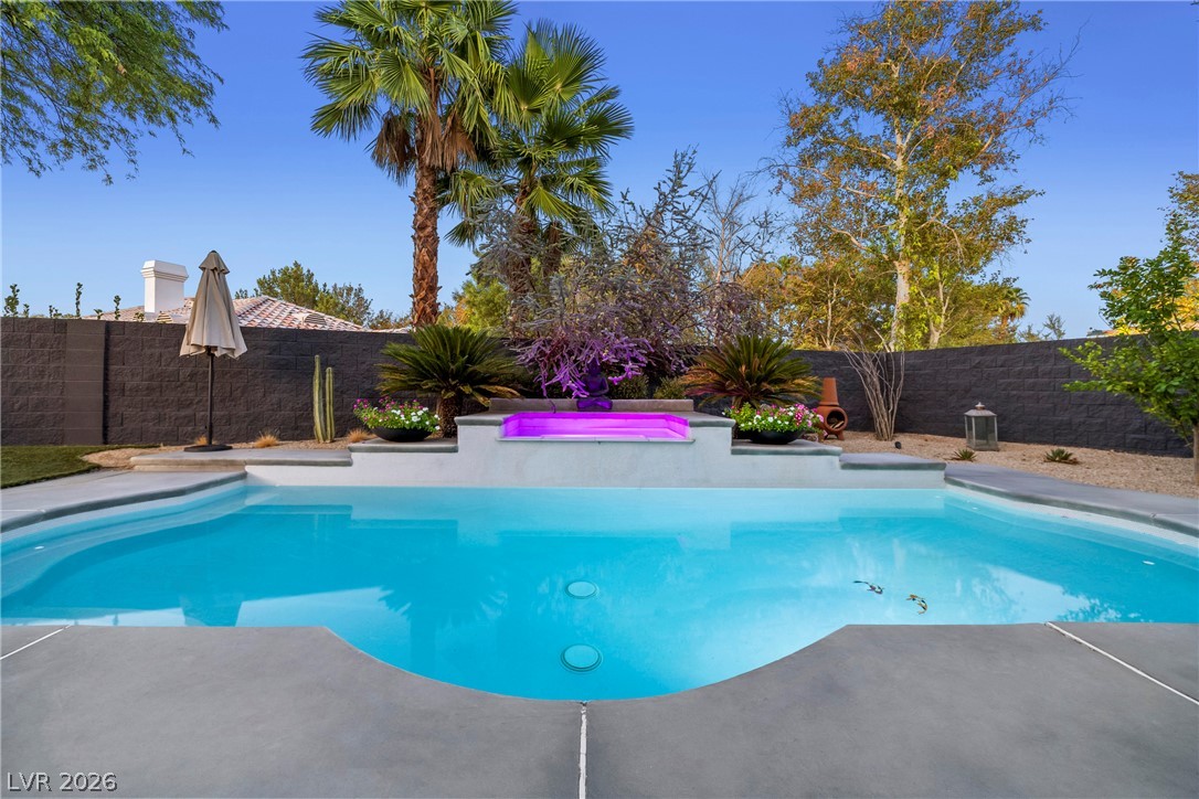 2000 Grouse Street Las Vegas, NV 89134 - Photo 58 of 89 A private oasis awaits with a pristine pool and spa, set against vibrant landscaping.