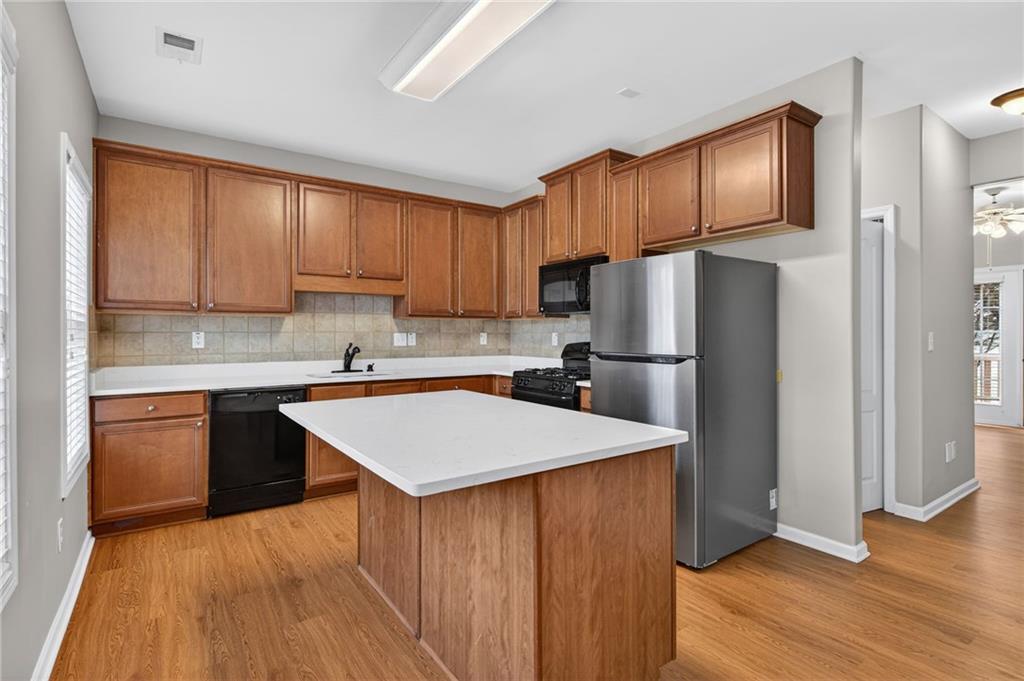 1186 Lake Point Way Suwanee, GA 30024 - Photo 6 of 35 a kitchen with wooden cabinets a refrigerator and a sink