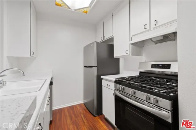 a kitchen with granite countertop a stove and a refrigerator