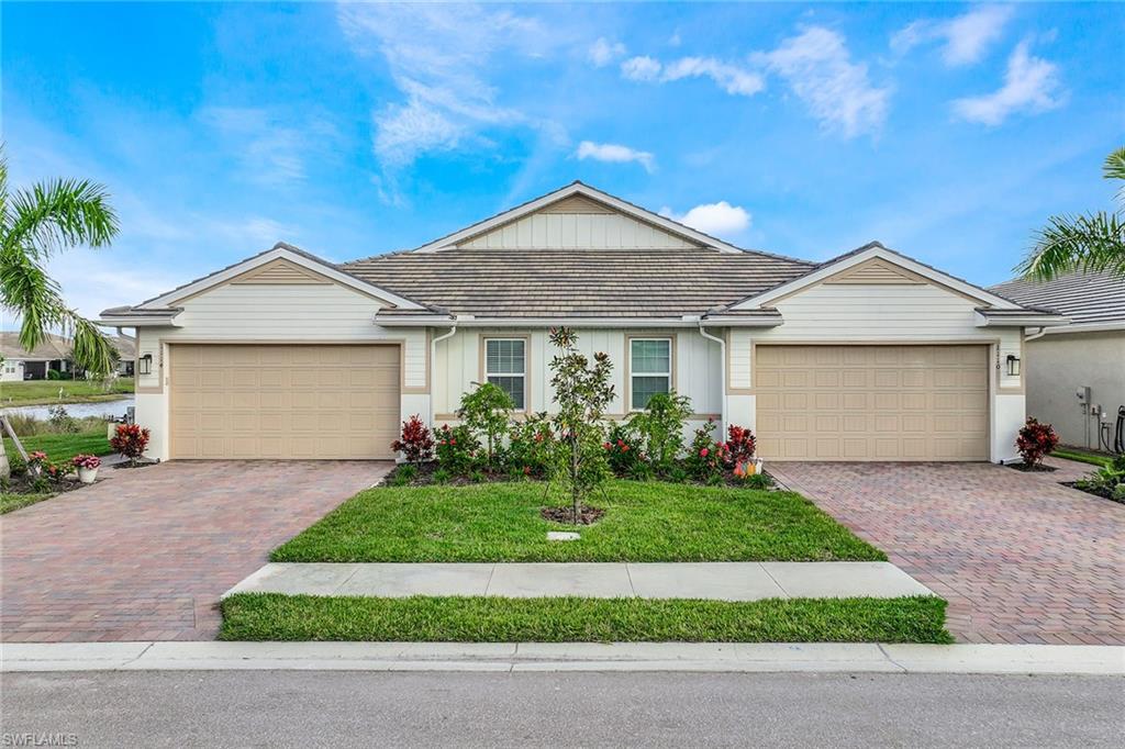 1114 Tranquil Brook Drive Naples, FL 34114 - Photo 32 of 32 a front view of a house with a yard and garage