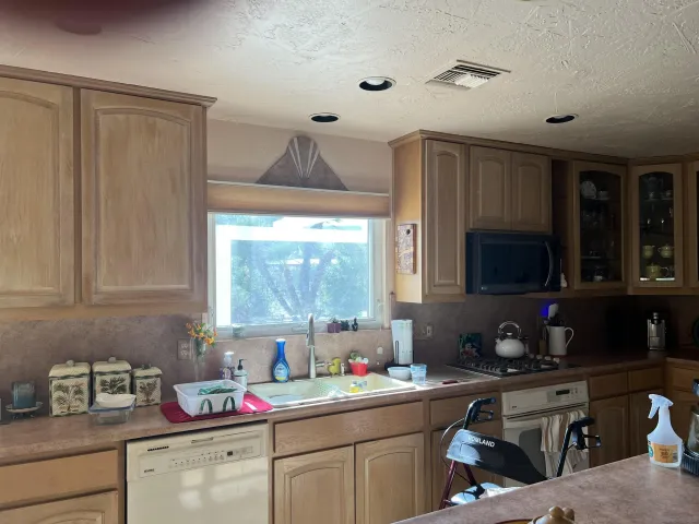 a kitchen with granite countertop cabinets sink and window