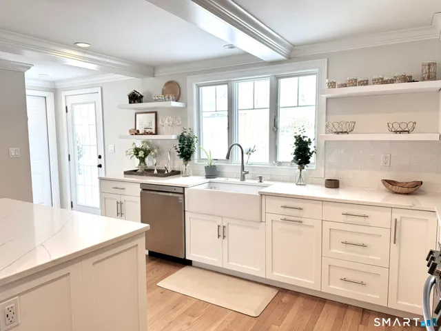 a kitchen with white cabinets and white appliances