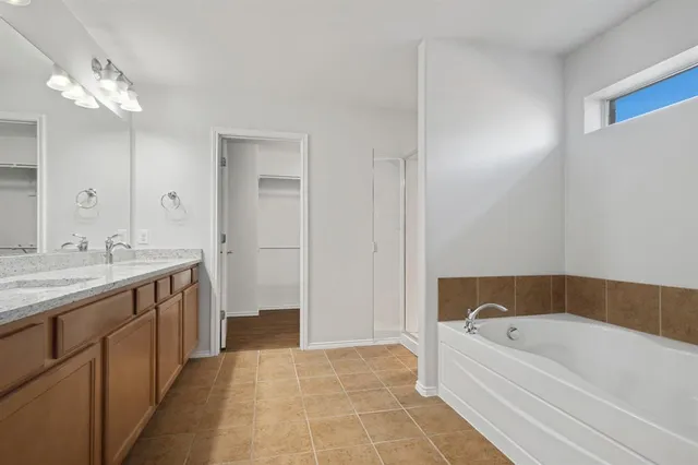 a bathroom with a tub sink and mirror