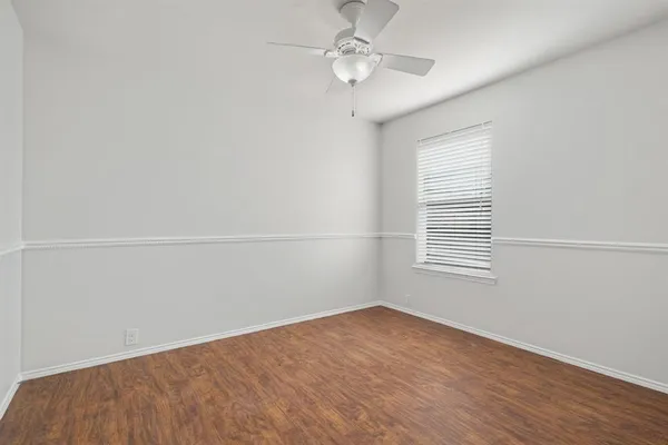 an empty room with a window and ceiling fan