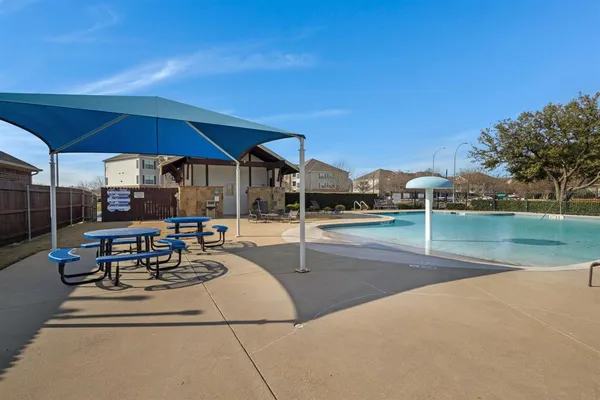 a view of a patio with a table and chairs under an umbrella