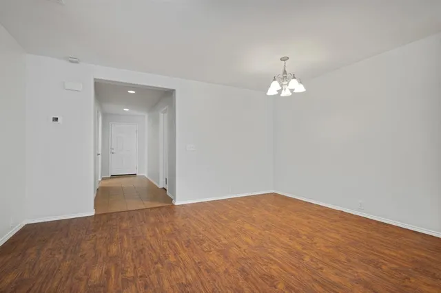 a view of a room with wooden floor and a chandelier