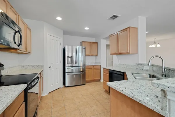 a kitchen with stainless steel appliances granite countertop a sink stove and refrigerator