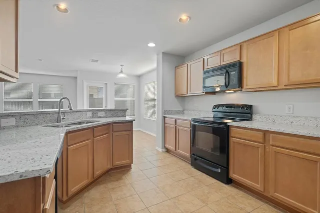 a kitchen with stainless steel appliances granite countertop a sink and a stove top oven