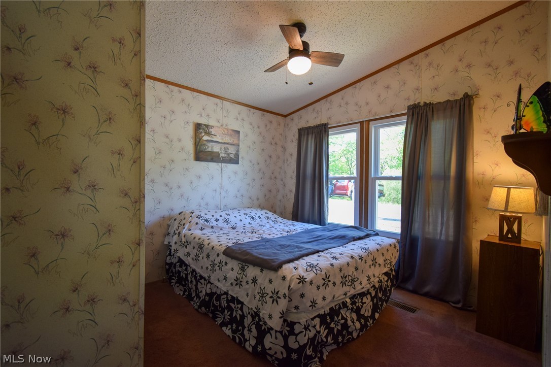 26933 Marina Road Freeport, OH 43973 - Photo 10 of 18 Bedroom featuring lofted ceiling, ceiling fan, crown molding, and a textured ceiling