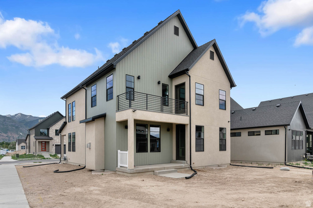 1567 North 3250 West Provo, UT 84601 - Photo 3 of 22 Contemporary stucco and board and batten exterior with black-framed windows, a second-story balcony with black railings, a covered patio, and a mountain backdrop
