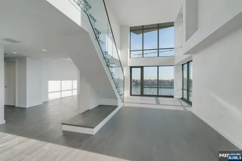 an empty room with windows and stairs