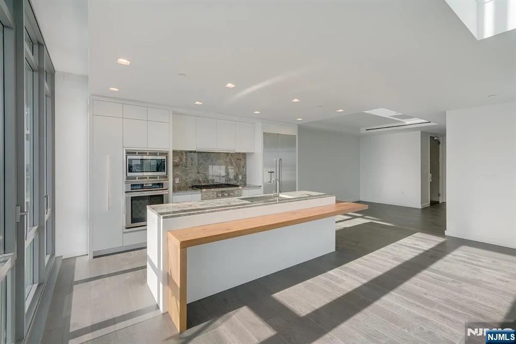 320 Adolphus Avenue, Unit 316 Cliffside Park, NJ 07010 - Photo 7 of 34 a large kitchen with kitchen island a sink stainless steel appliances and cabinets