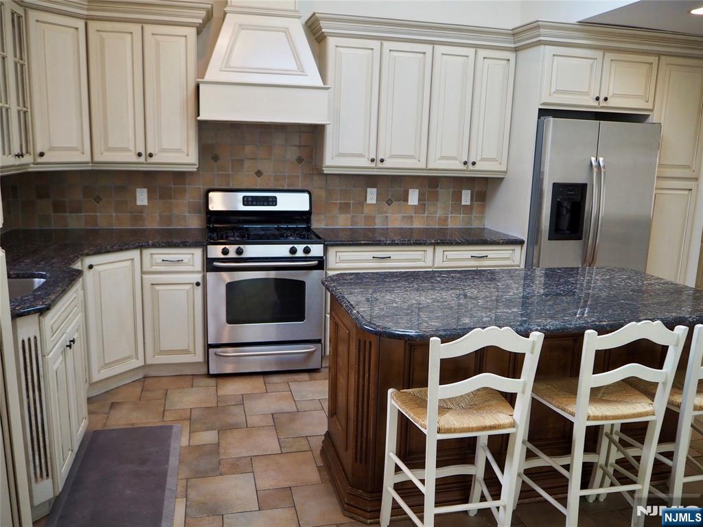 744 Hamilton Avenue, Unit 1 Ridgefield, NJ 07657 - Photo 2 of 29 a kitchen with granite countertop a stove a sink and a refrigerator