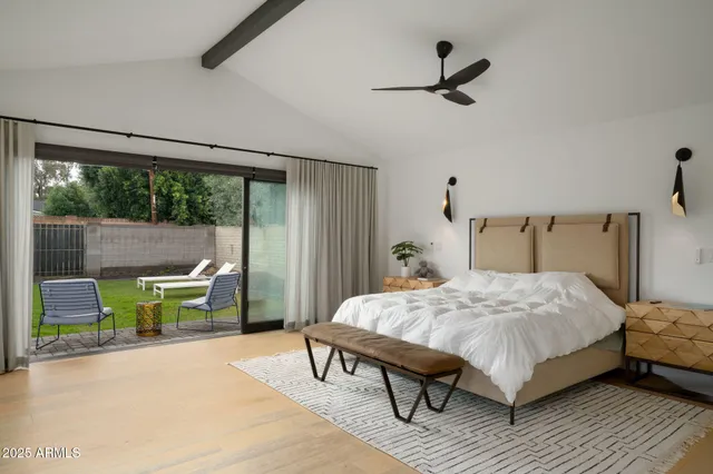 a bedroom with a bed a table and a large window