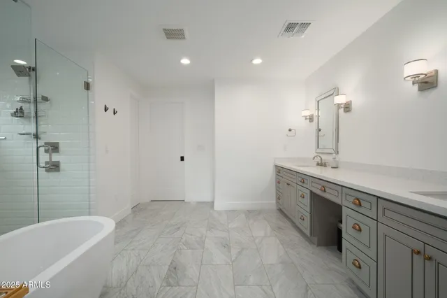 a spacious bathroom with a tub sink and mirror
