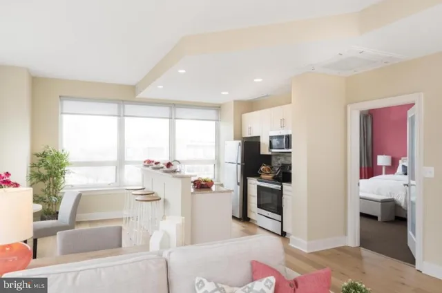 a kitchen with stainless steel appliances granite countertop a stove top oven a sink dishwasher and wooden cabinets with wooden floor