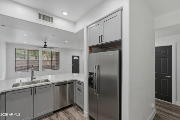 a kitchen with cabinets stainless steel appliances and sink