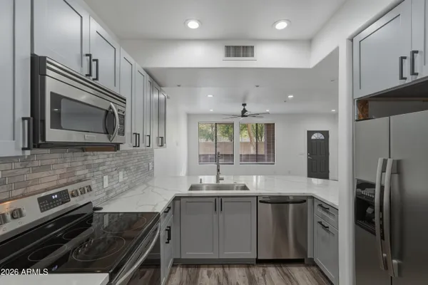 a kitchen with stainless steel appliances granite countertop a refrigerator and a sink
