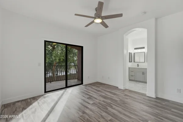 an empty room with wooden floor and balcony