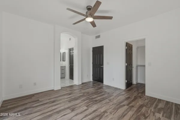 a view of an empty room with a window and wooden floor