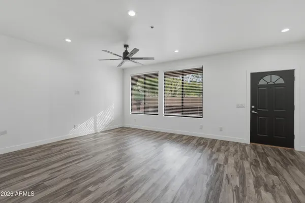 a view of an empty room with a window and wooden floor