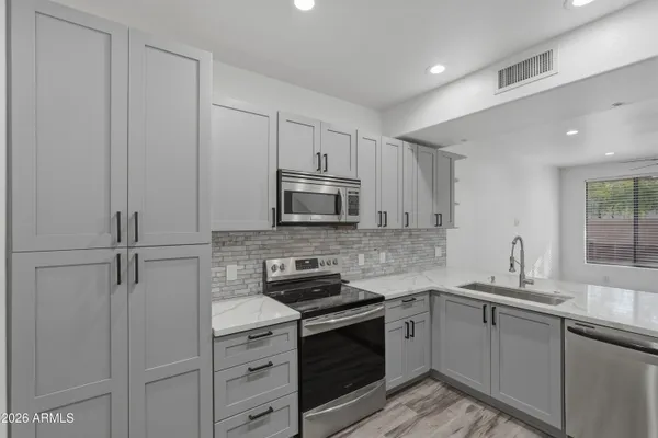 a kitchen with stainless steel appliances a sink stove and cabinets