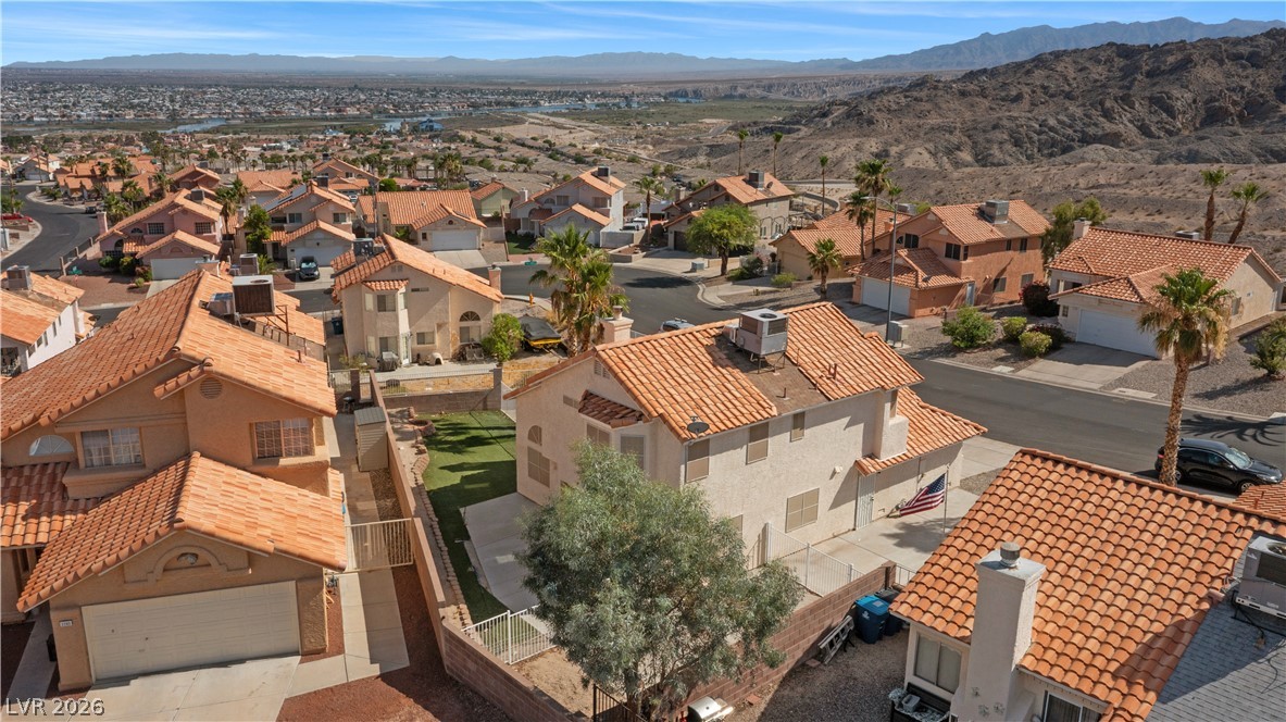 3156 Terrace View Drive Laughlin, NV 89029 - Photo 89 of 94 An aerial perspective showcases a vibrant desert community with traditional tile-roofed homes nestled against rugged mountain vistas.