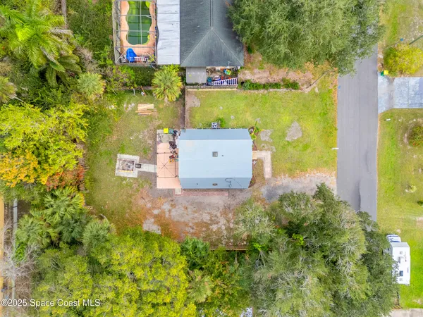 an aerial view of a house with a yard basket ball court and outdoor seating