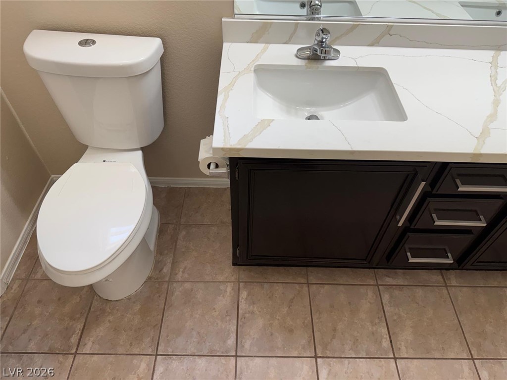 3962 Coyote Ridge Court Las Vegas, NV 89129 - Photo 21 of 35 A pristine bathroom featuring a contemporary vanity with a gleaming countertop and an updated toilet.