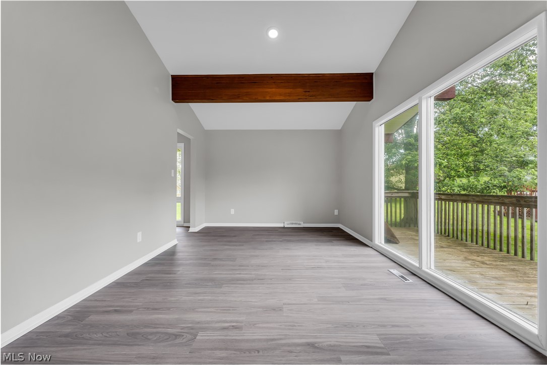 6190 Mill Road Broadview Heights, OH 44147 - Photo 10 of 36 Spare room featuring a healthy amount of sunlight, vaulted ceiling with beams, and wood-type flooring