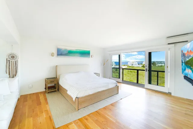 a kitchen with stainless steel appliances wooden floor and a large window