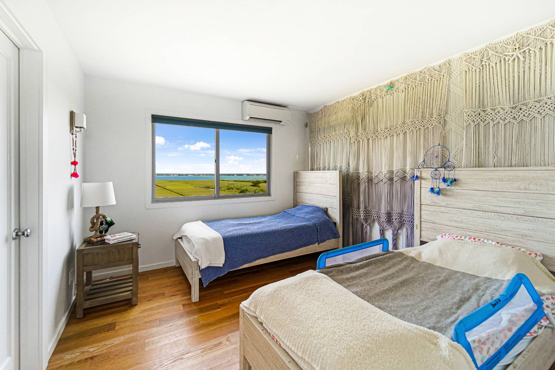 548 Dune Road Westhampton, NY 11978 - Photo 19 of 34 a bedroom with a bed and wooden floor