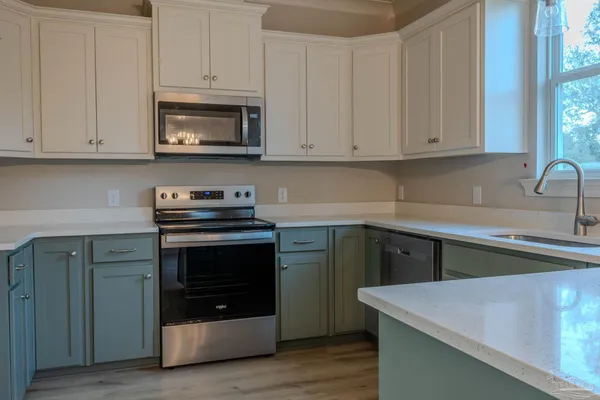 a kitchen with cabinets appliances and a sink