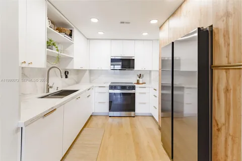 a kitchen with kitchen island a sink stainless steel appliances and cabinets