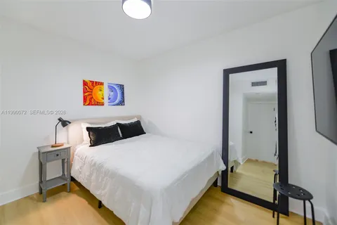 a bedroom with a bed and painting on the wall