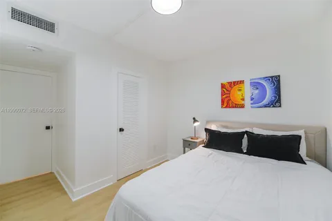 a bedroom with a bed and large windows