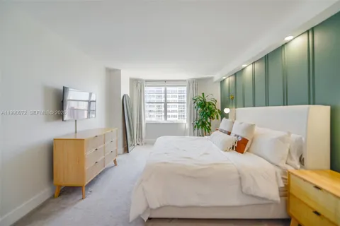 a bedroom with a bed and a potted plant