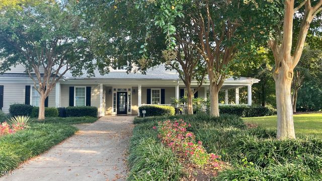 a front view of a house with garden bath tub and trees