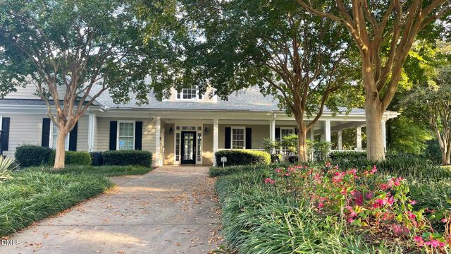 a view of a patio with table and chairs potted plants with wooden floor and fence