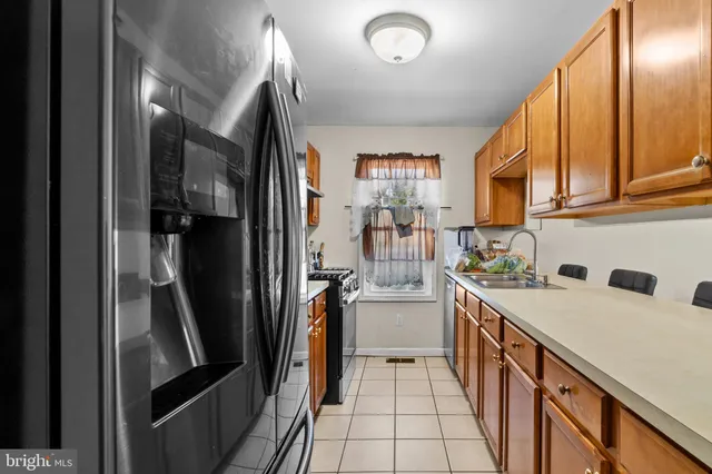 a kitchen with a sink stainless steel appliances a refrigerator and cabinets