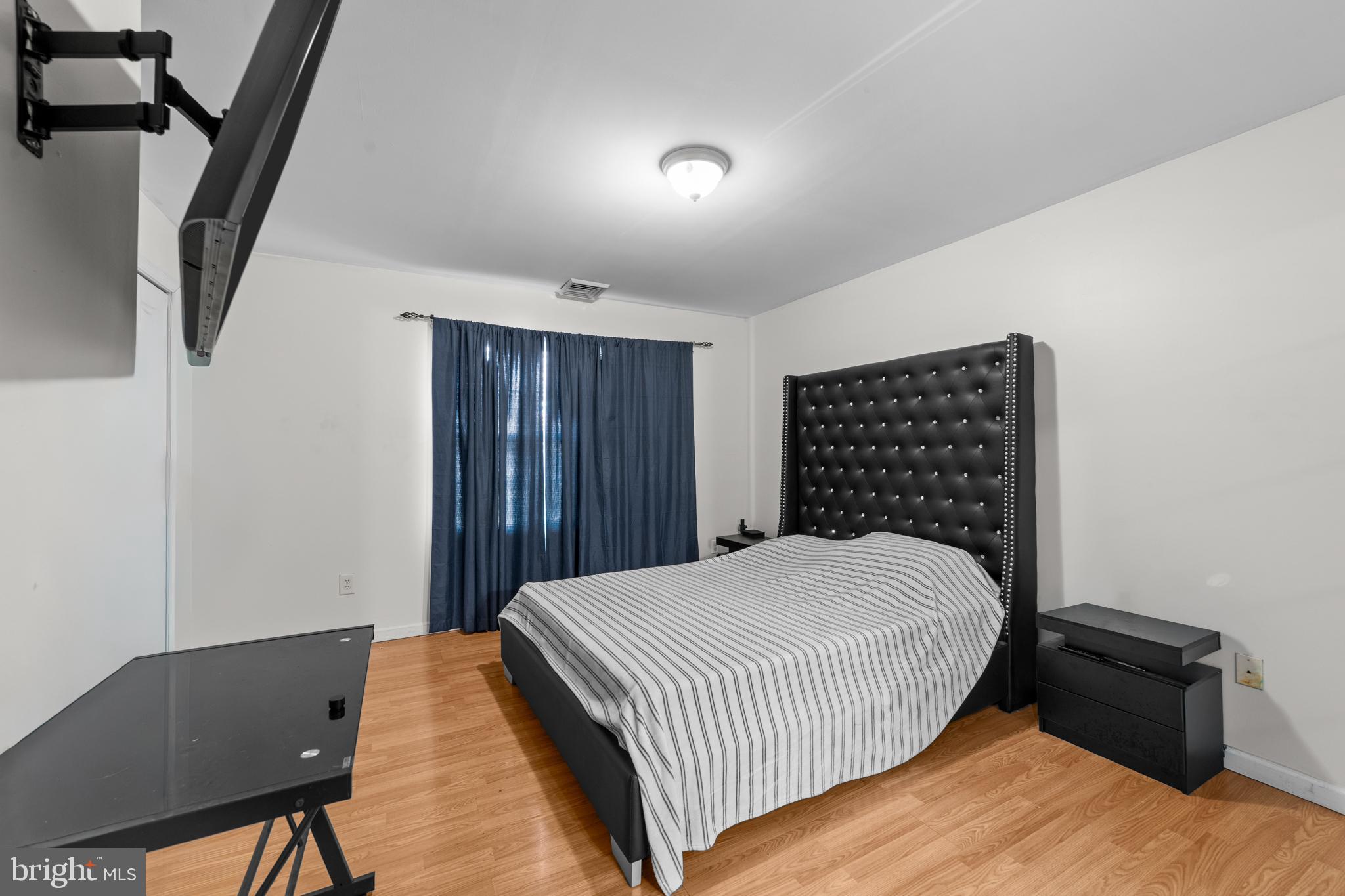 80 Larch Avenue New Brunswick, NJ 08901 - Photo 15 of 24 a bedroom with a bed and wooden floor