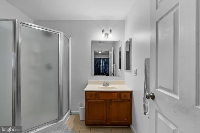a bathroom with a shower sink and mirror