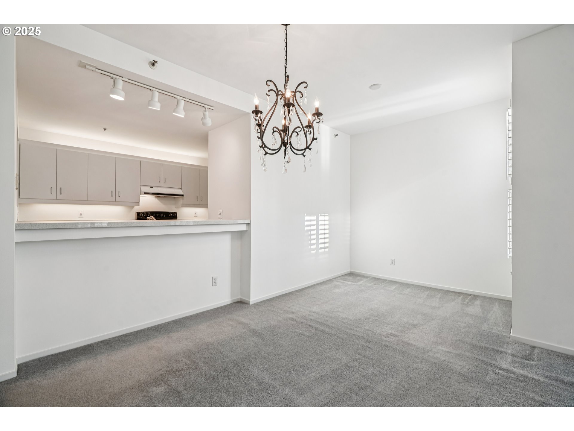 1616 South Harbor Way, Unit 402 Portland, OR 97201 - Photo 9 of 34 a kitchen with kitchen island white cabinets and refrigerator