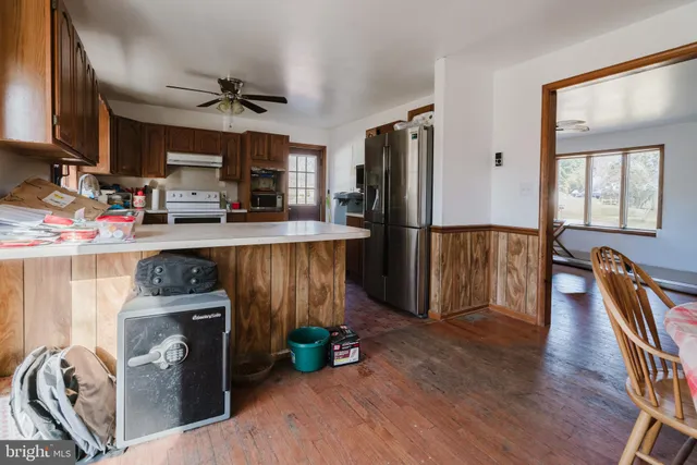 a kitchen with granite countertop a refrigerator stove and wooden floor