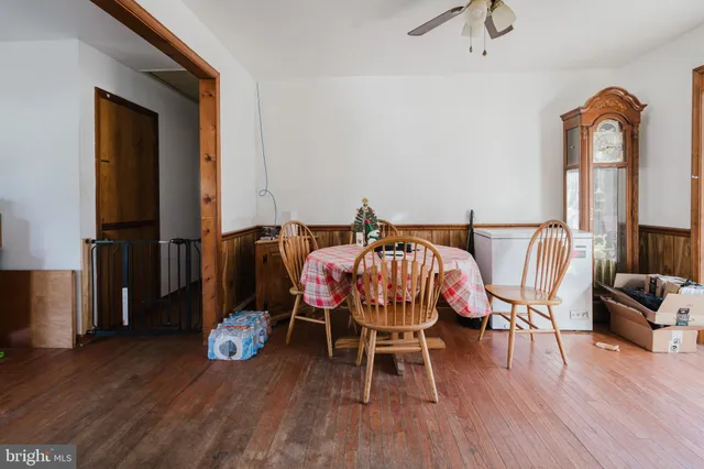 a dining room with furniture a chandelier and wooden floor