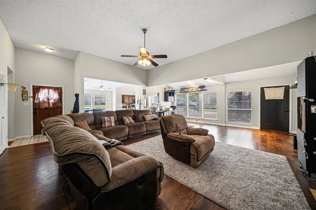 a living room with furniture ceiling fan and a wooden floor