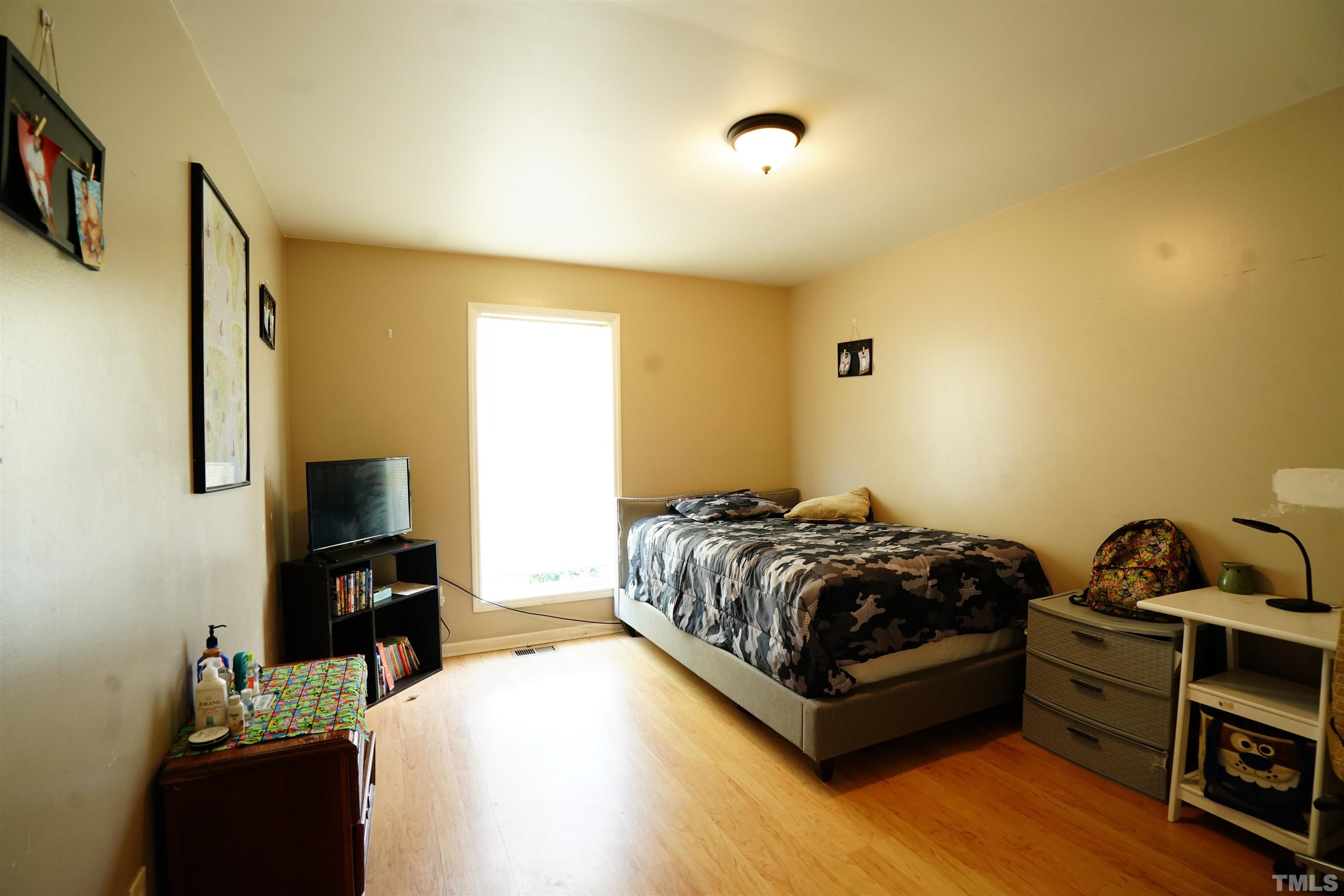 1212 Cranmoore Court Raleigh, NC 27604 - Photo 2 of 14 a bedroom with a bed and flat screen tv