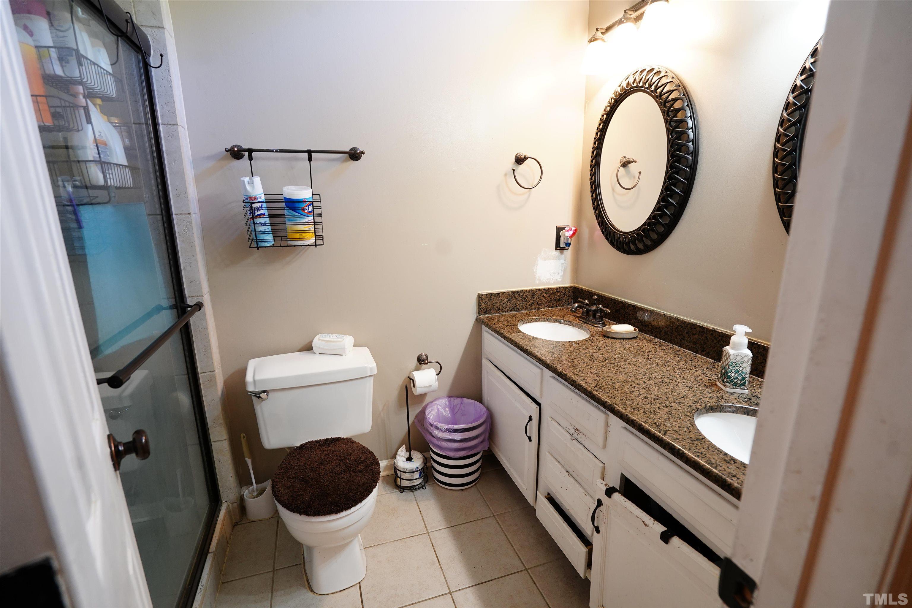 1212 Cranmoore Court Raleigh, NC 27604 - Photo 6 of 14 a bathroom with a granite countertop toilet sink and mirror
