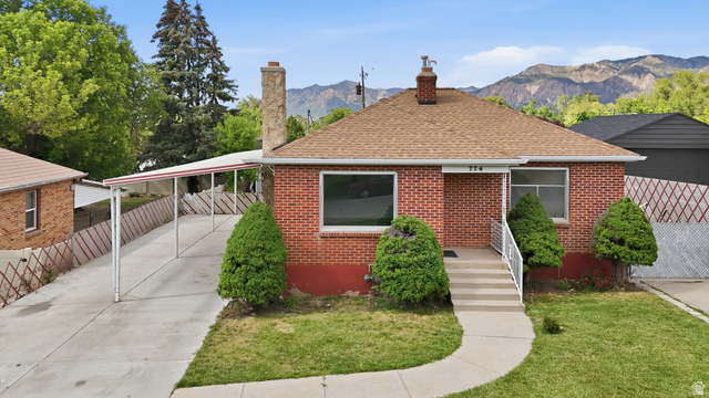 774 37th Street South Ogden, UT 84403 - Photo 43 of 47 Brick exterior residence featuring a front entry with concrete steps and white railings, a covered carport, and a prominent chimney